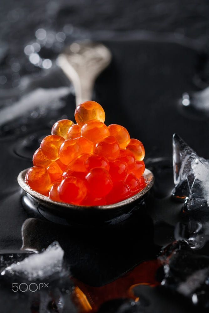 a spoon full of gummy bears sitting on top of ice