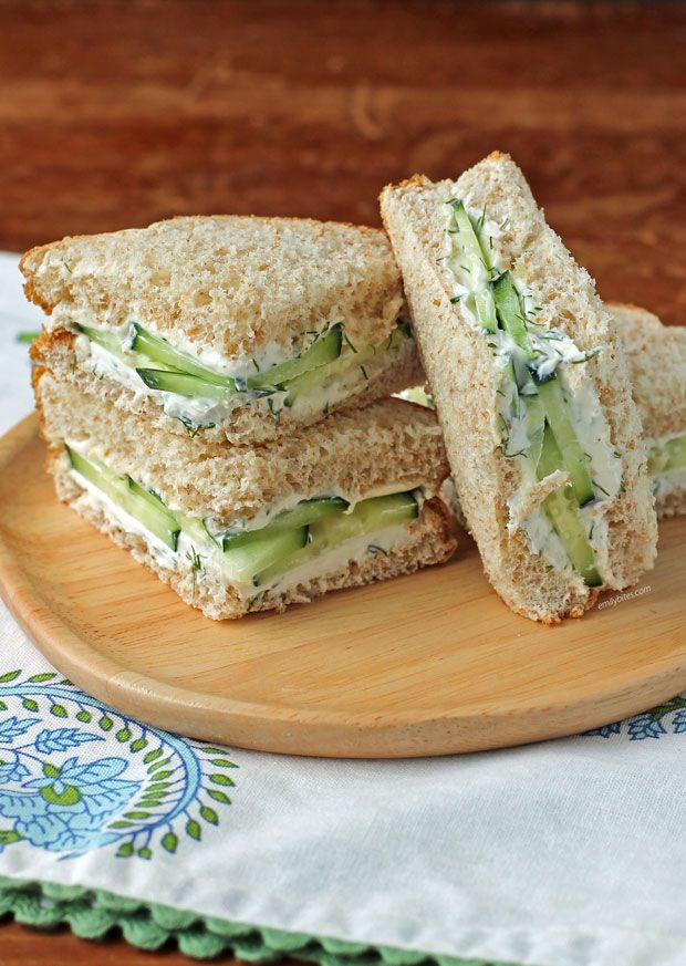 a sandwich cut in half sitting on top of a wooden plate next to a napkin