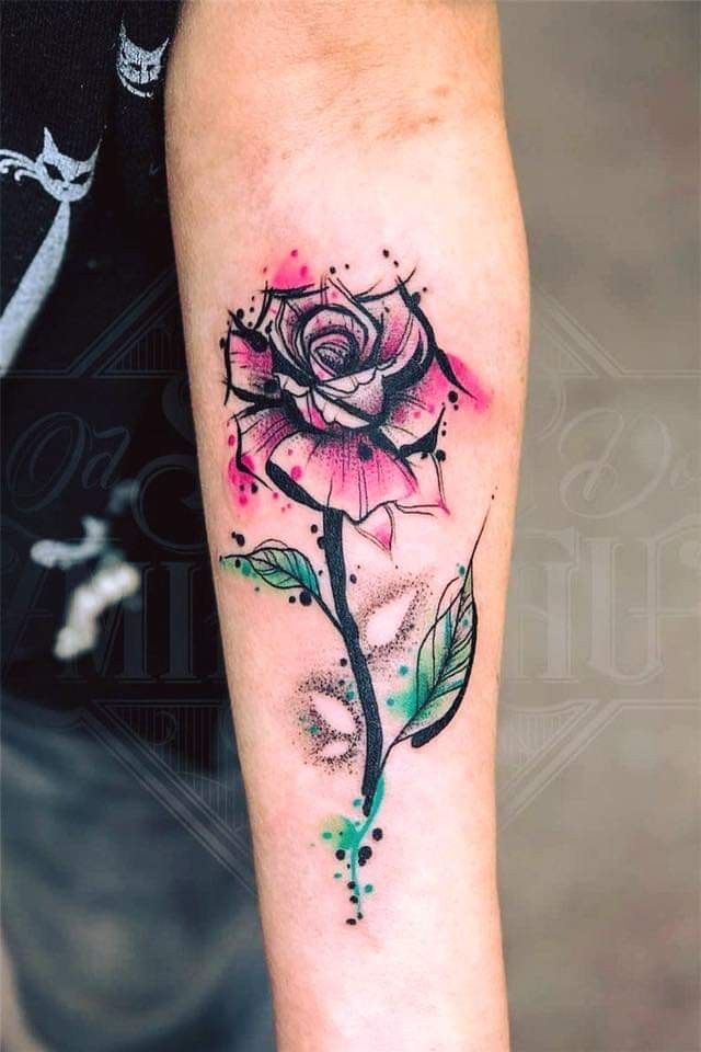 a rose tattoo on the arm with watercolor paint splatters and leaves around it