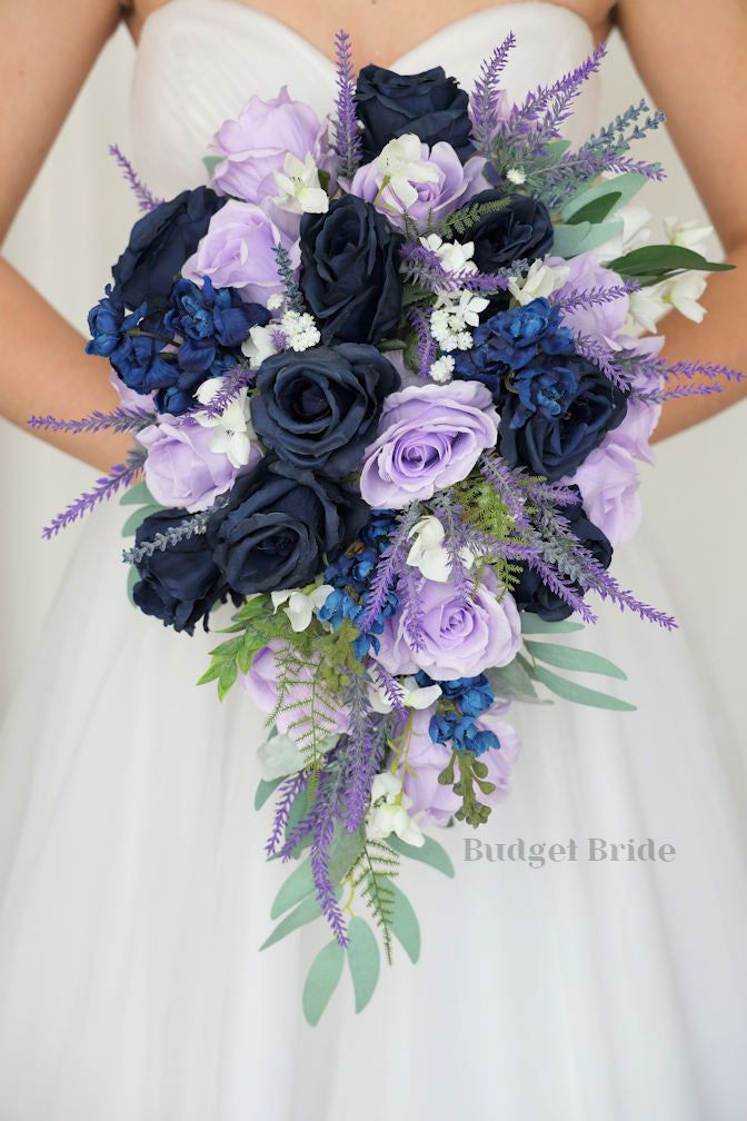 a bride holding a purple and blue bouquet