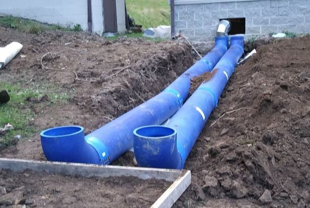 a blue pipe laying in the dirt next to a building