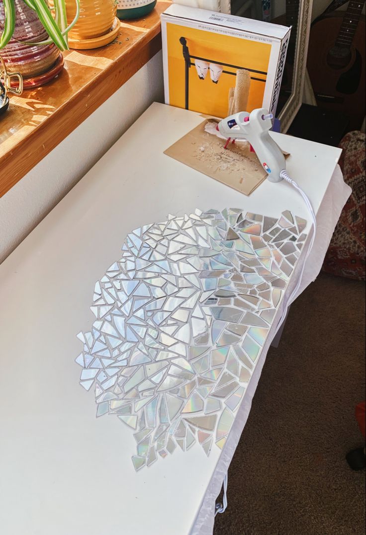 a white table topped with lots of different types of glass shards and vases on top of it