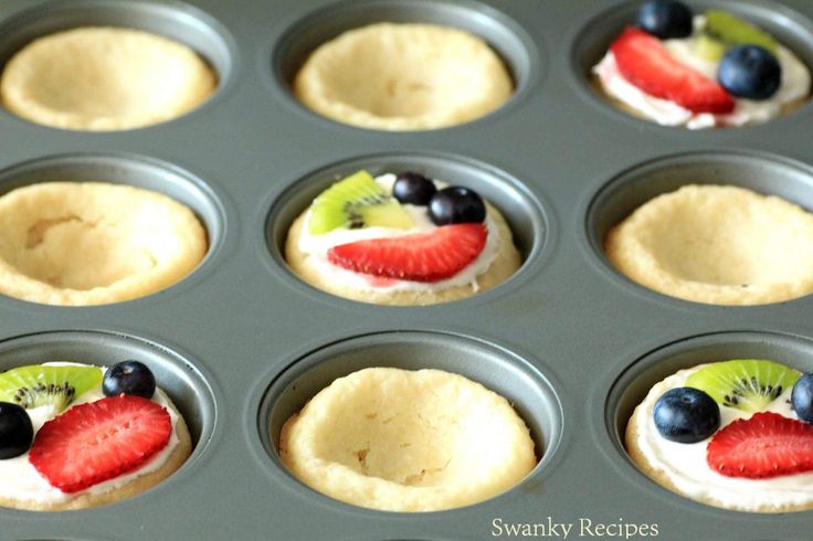 cupcakes with fruit on top in a muffin tin