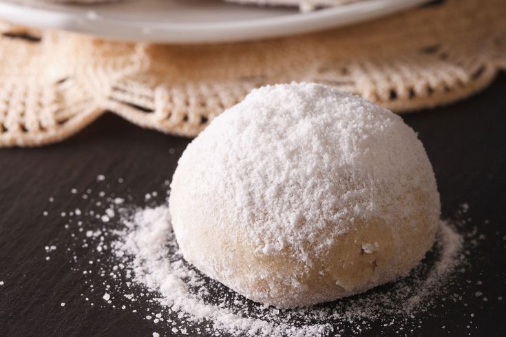 a ball of powdered sugar sitting on top of a table next to a plate