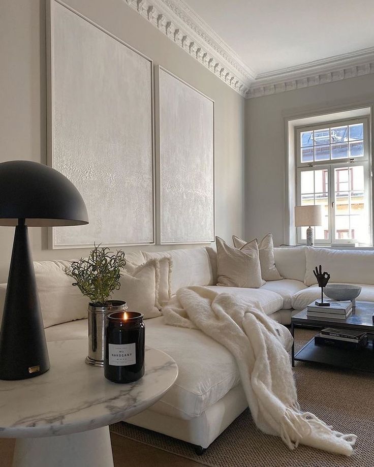 a living room filled with furniture and a large white couch next to a coffee table