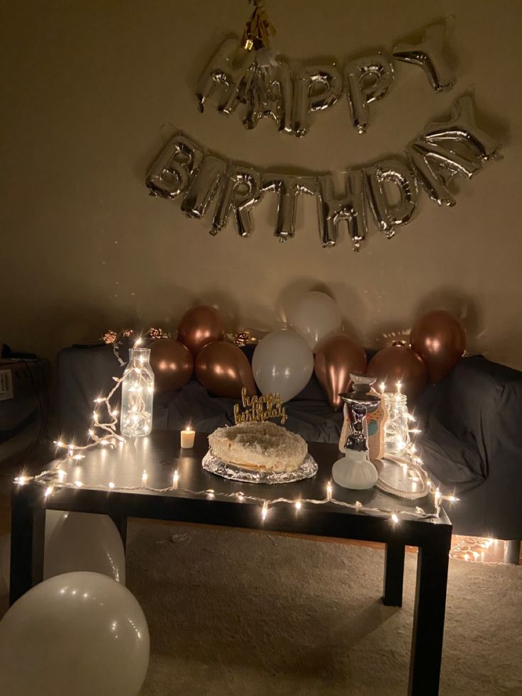 a birthday cake on a table surrounded by balloons