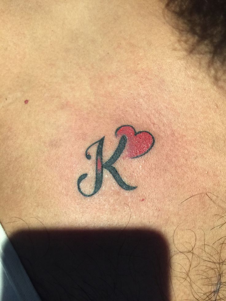 a person with a tattoo on their neck and the letter k is in the shape of a heart