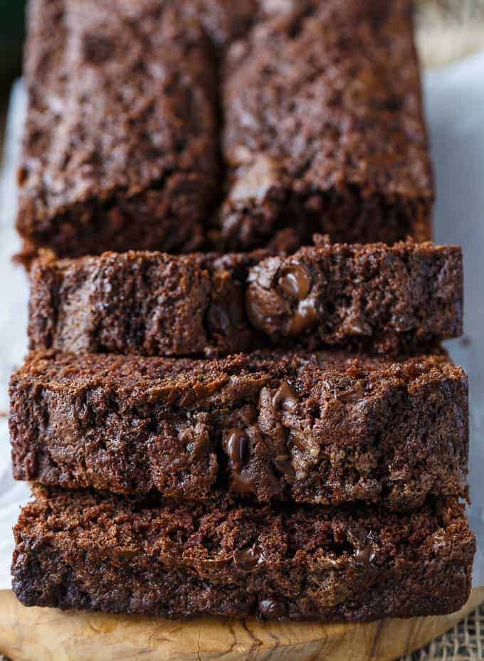 three slices of chocolate brownie on a wooden cutting board