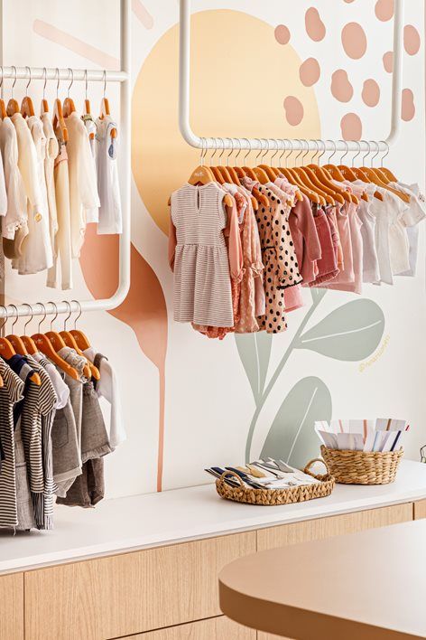 clothes hanging on racks in a children's clothing store