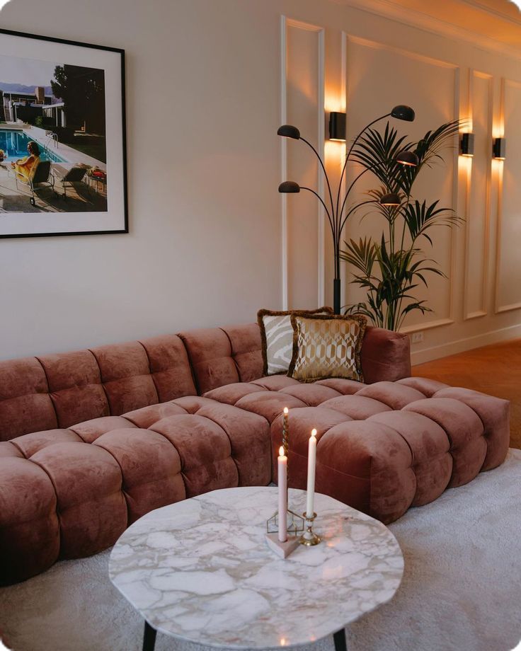 a living room with a couch, coffee table and two candles on the end tables