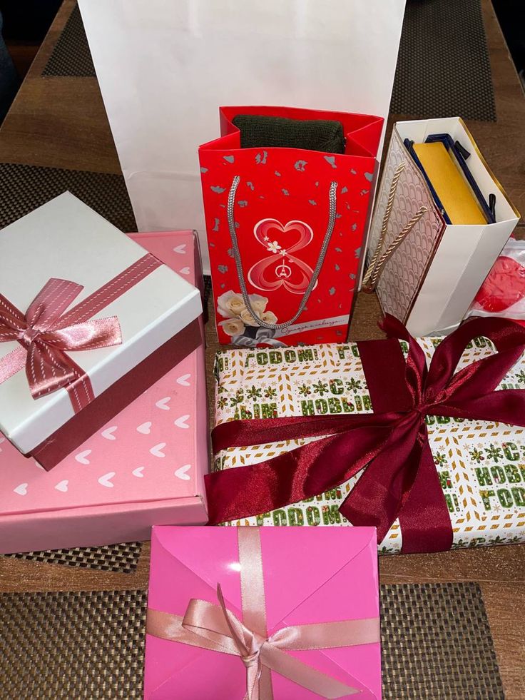 several gift boxes wrapped in pink and red ribbon