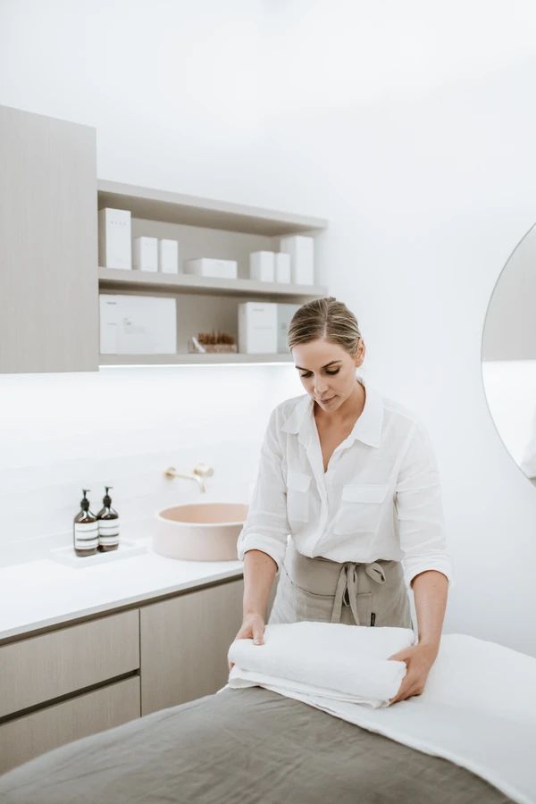 a woman in white shirt and khaki pants ironing clothes