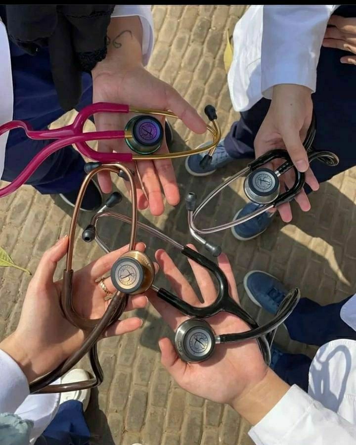 several doctors are holding their stethoscopes together