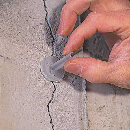 a man is working on the side of a building with cement being poured onto it