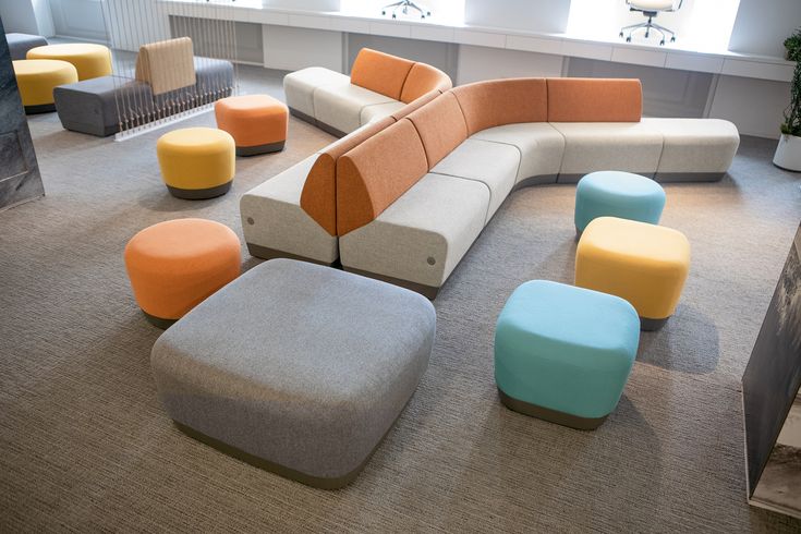 a room with many different colored couches and stools