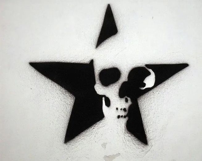 a black and white image of a star with a skull on it's side