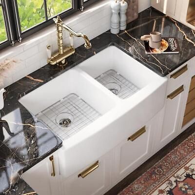 a kitchen with marble counter tops and white double basin sinks in front of a window