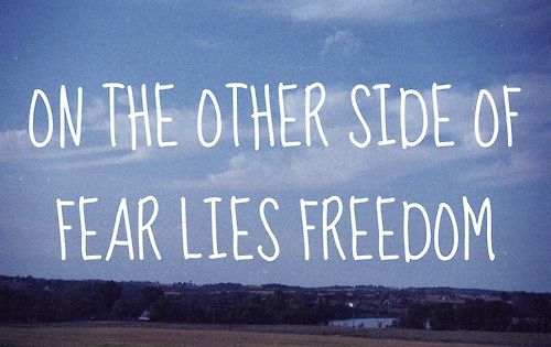 a field with the words on the other side of fear lies freedom written in white