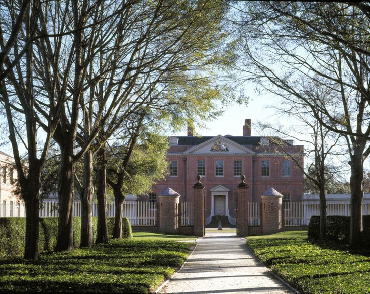 a large brick house surrounded by trees and hedges