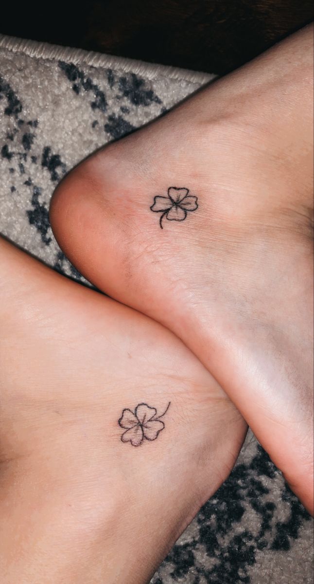 two people with small tattoos on their feet, one has a clover and the other has a four leaf clover