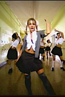 a group of young people dancing in a school dance hall with one woman wearing a skirt and the other holding her hands up