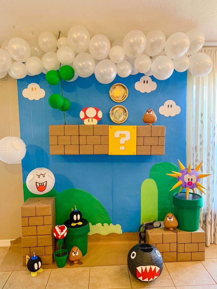 a nintendo themed birthday party with balloons and paper mario's house on the wall