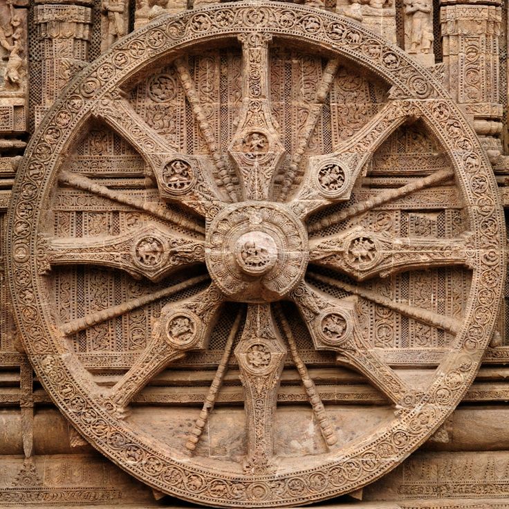 an intricately carved wheel on the side of a building