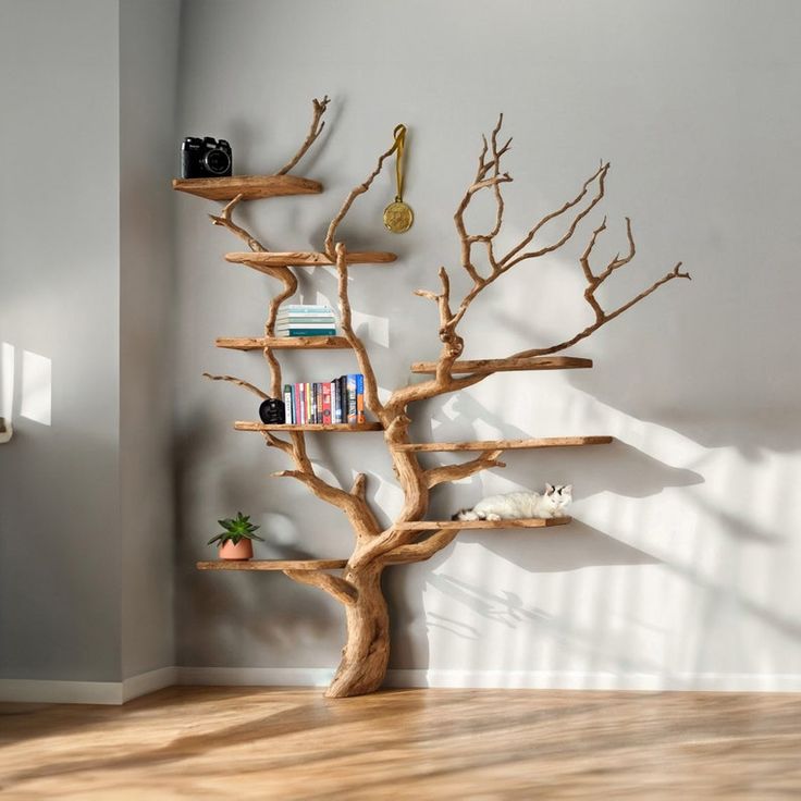 a wooden tree shelf with books on it in a room next to a white wall