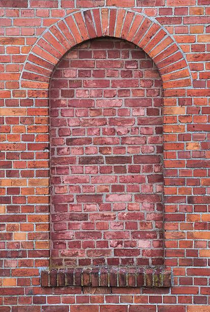 an arched window on a brick wall