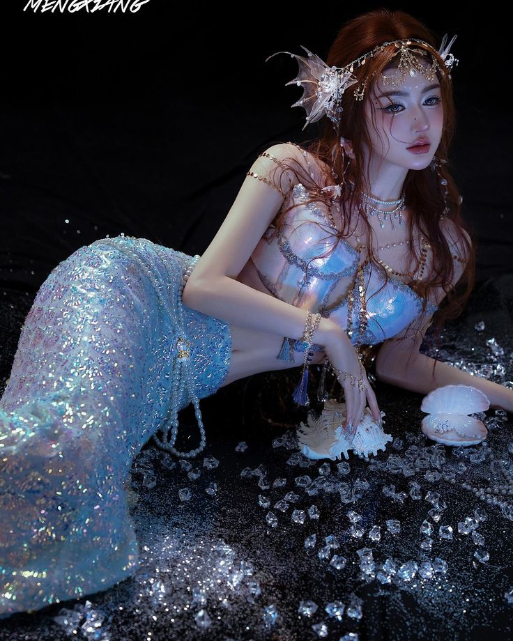 a woman dressed as a mermaid sitting on the ground