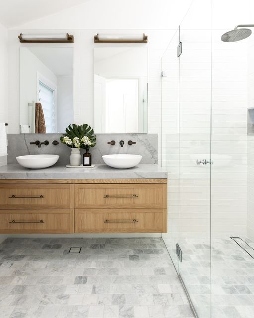 a bathroom with two sinks and a walk in shower