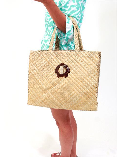 a woman is holding a straw bag and posing for the camera