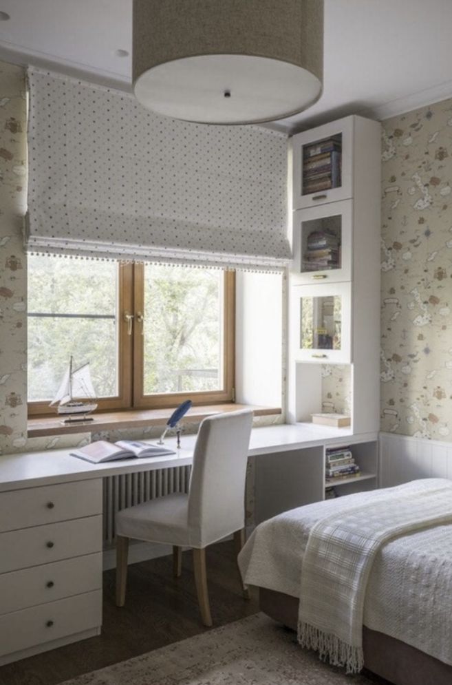 a bedroom with a bed, desk and bookshelf next to a large window