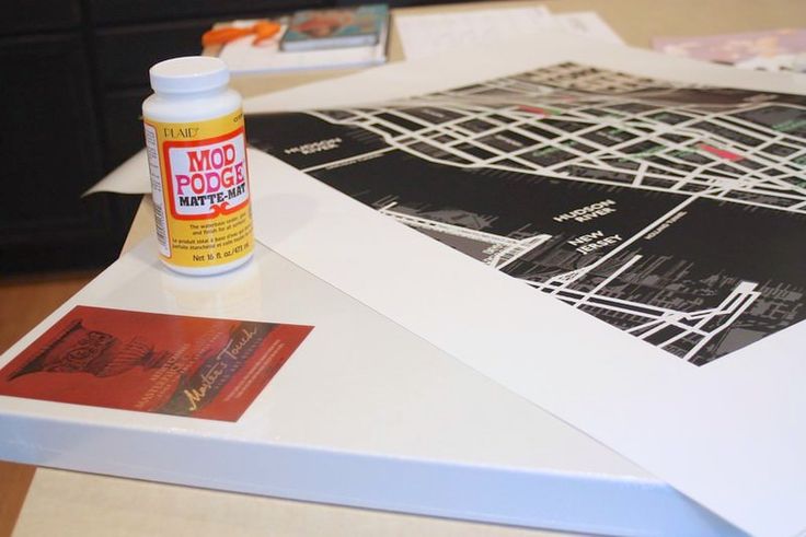 a bottle of glue sitting on top of a table next to some pictures and papers