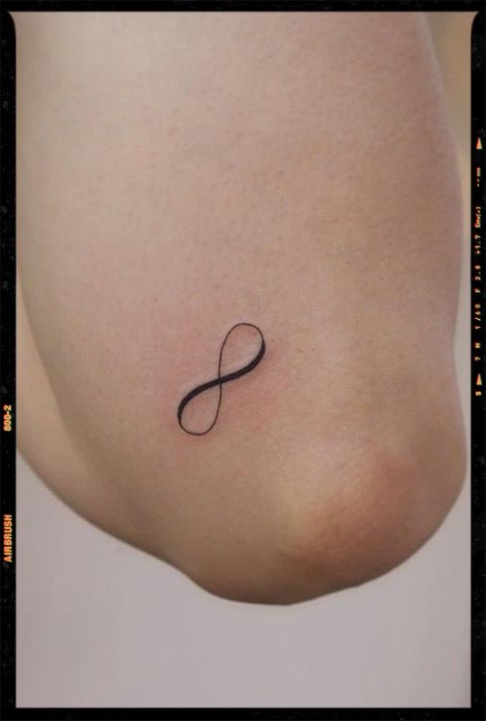 a woman's stomach with an infinite symbol tattoo on her left side ribcage