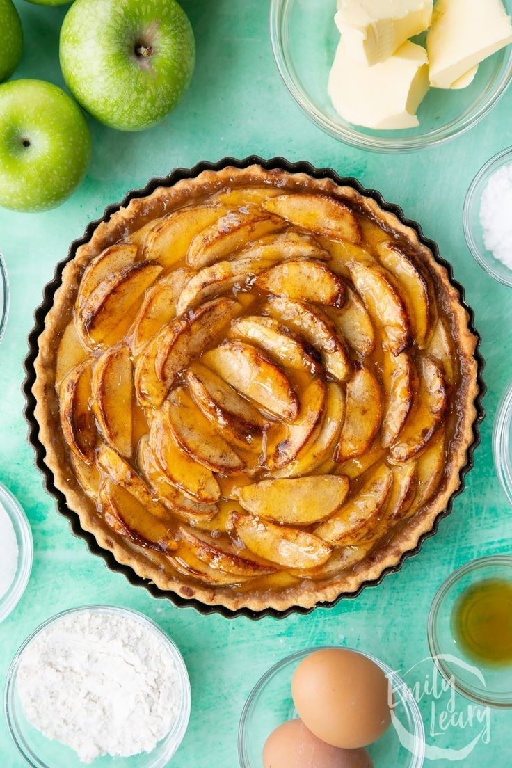 an apple pie with apples and other ingredients around it