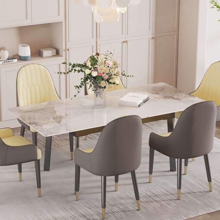 a dining room table with yellow chairs and a white marble topped centerpiece in the middle