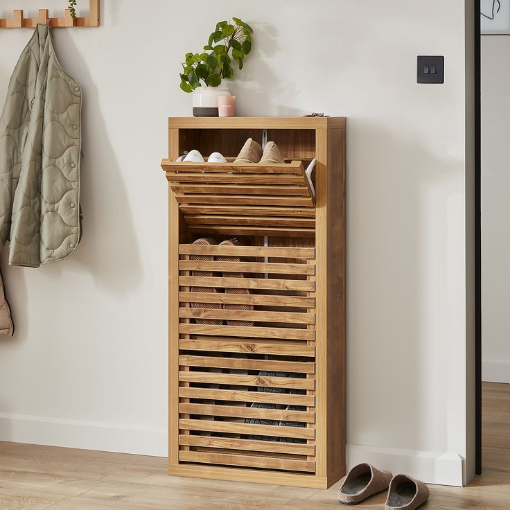 a wooden shoe rack sitting next to a coat rack