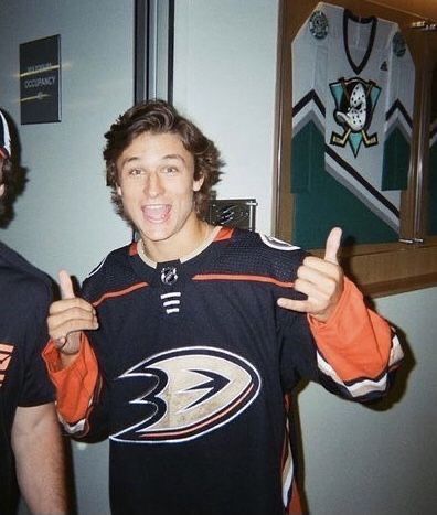 two men standing next to each other in front of a mirror with their thumbs up