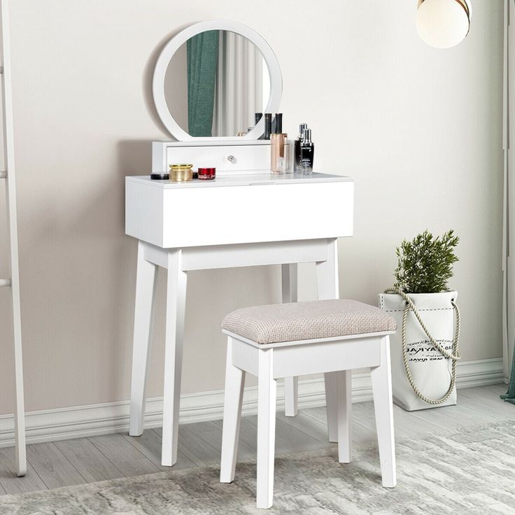 a white vanity table with a stool and mirror