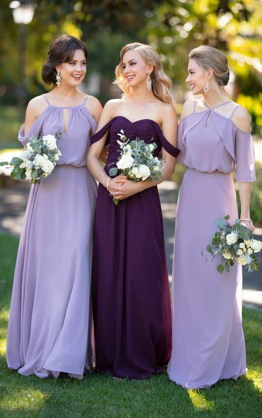 three bridesmaids in purple dresses posing for the camera