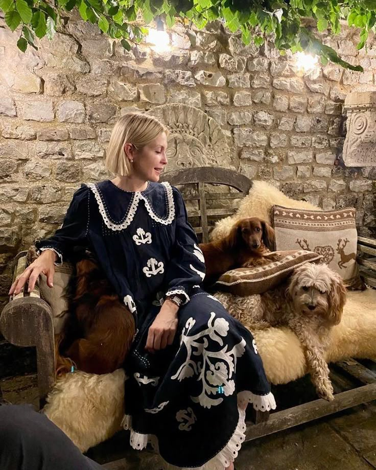 a woman sitting on a bench with two dogs