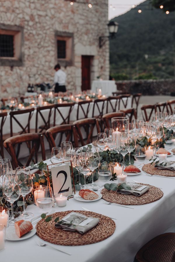 a long table is set with place settings and candles