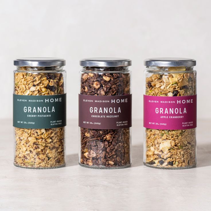 three jars filled with granola sitting on top of a table