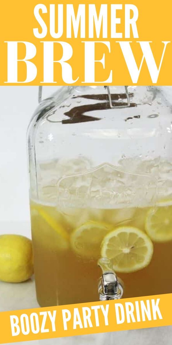 a mason jar filled with boozy party drink next to lemons and strawberries