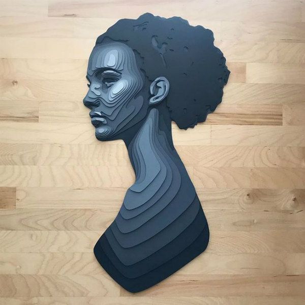 a paper cut out of a woman's head on a wooden floor with wood planks