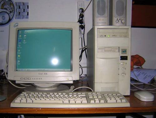 an old desktop computer sitting on top of a wooden desk