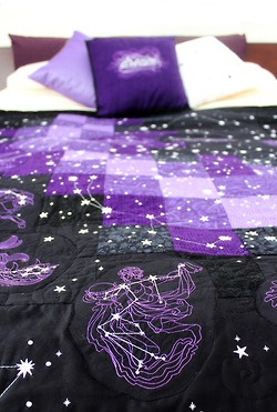 a purple and black bedspread with white stars on it