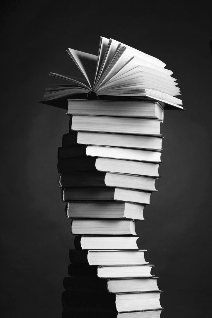 a stack of books sitting on top of each other in front of a black background