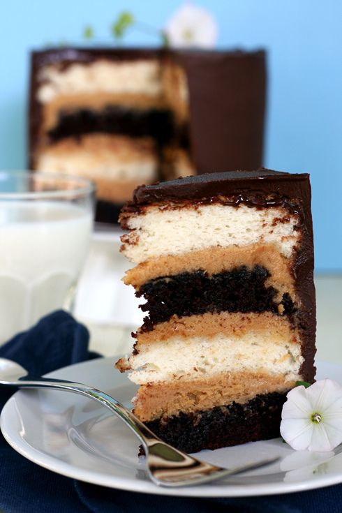 a piece of cake on a plate with a fork and glass of milk next to it